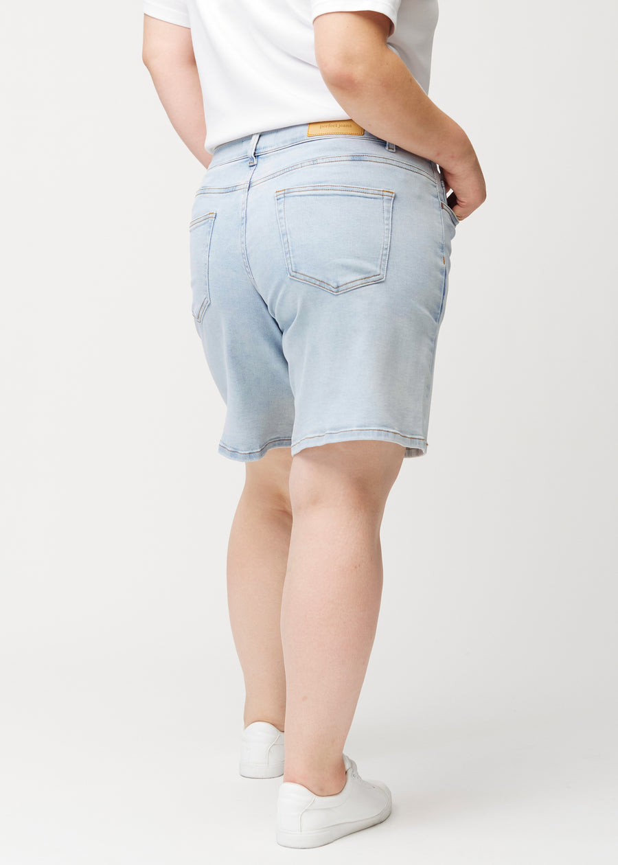 Kvinnlig modell sedd bakifrån i ljusblå Waves denimshorts.