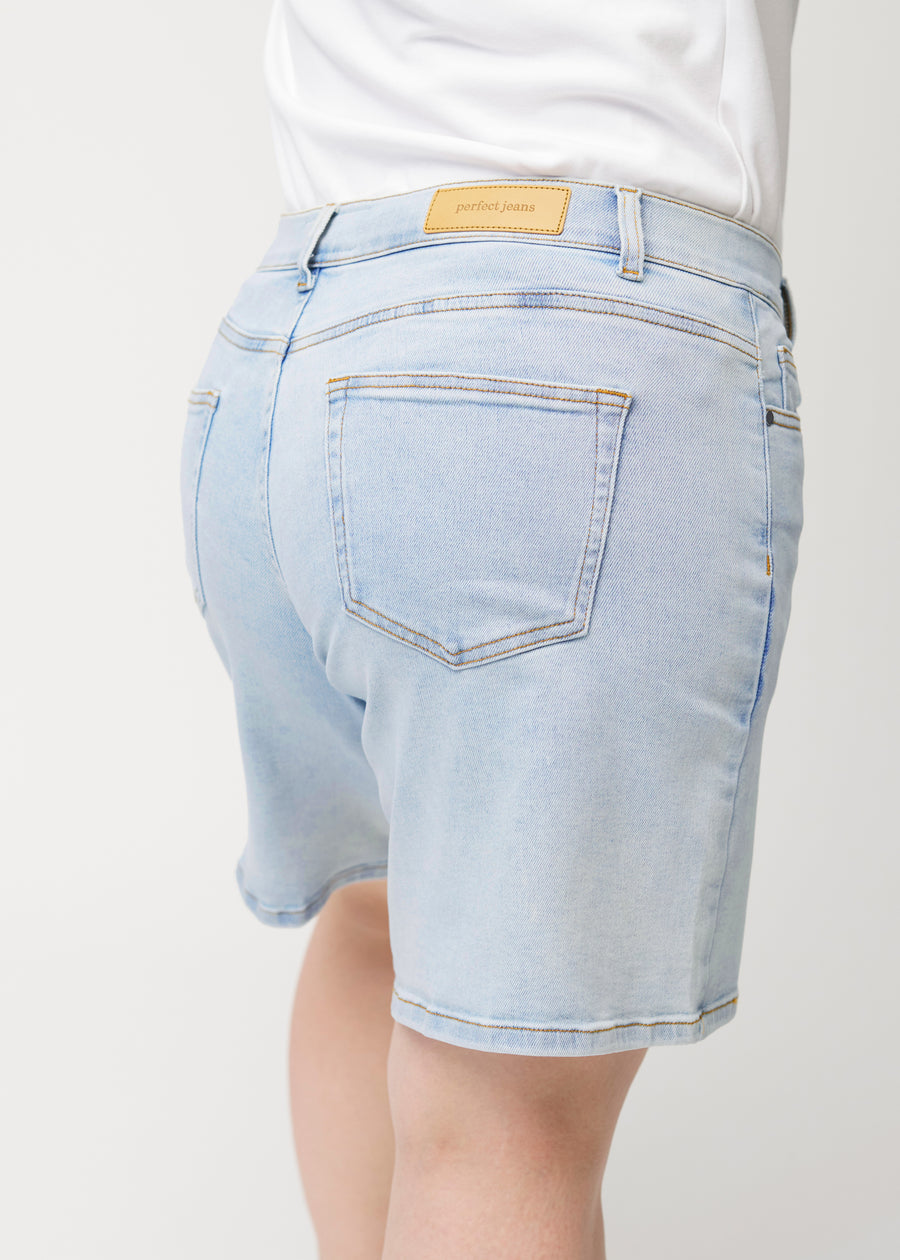 Närbild bakifrån av kvinnlig modell i ljusblå Waves denimshorts.