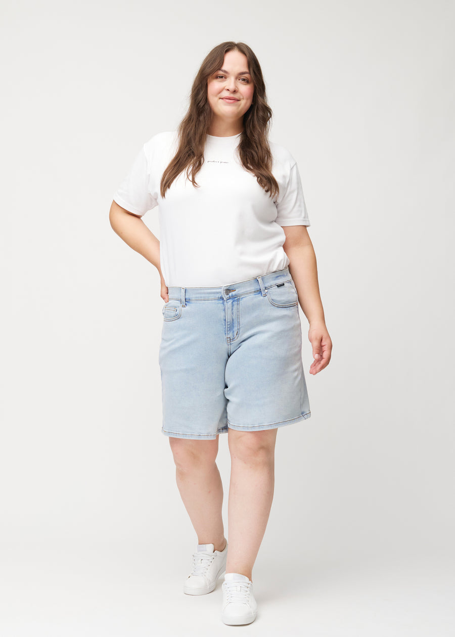 Helbild av kvinnlig modell i ljusblå Waves denimshorts med medelhög midja (Mid Rise) och loose fit.