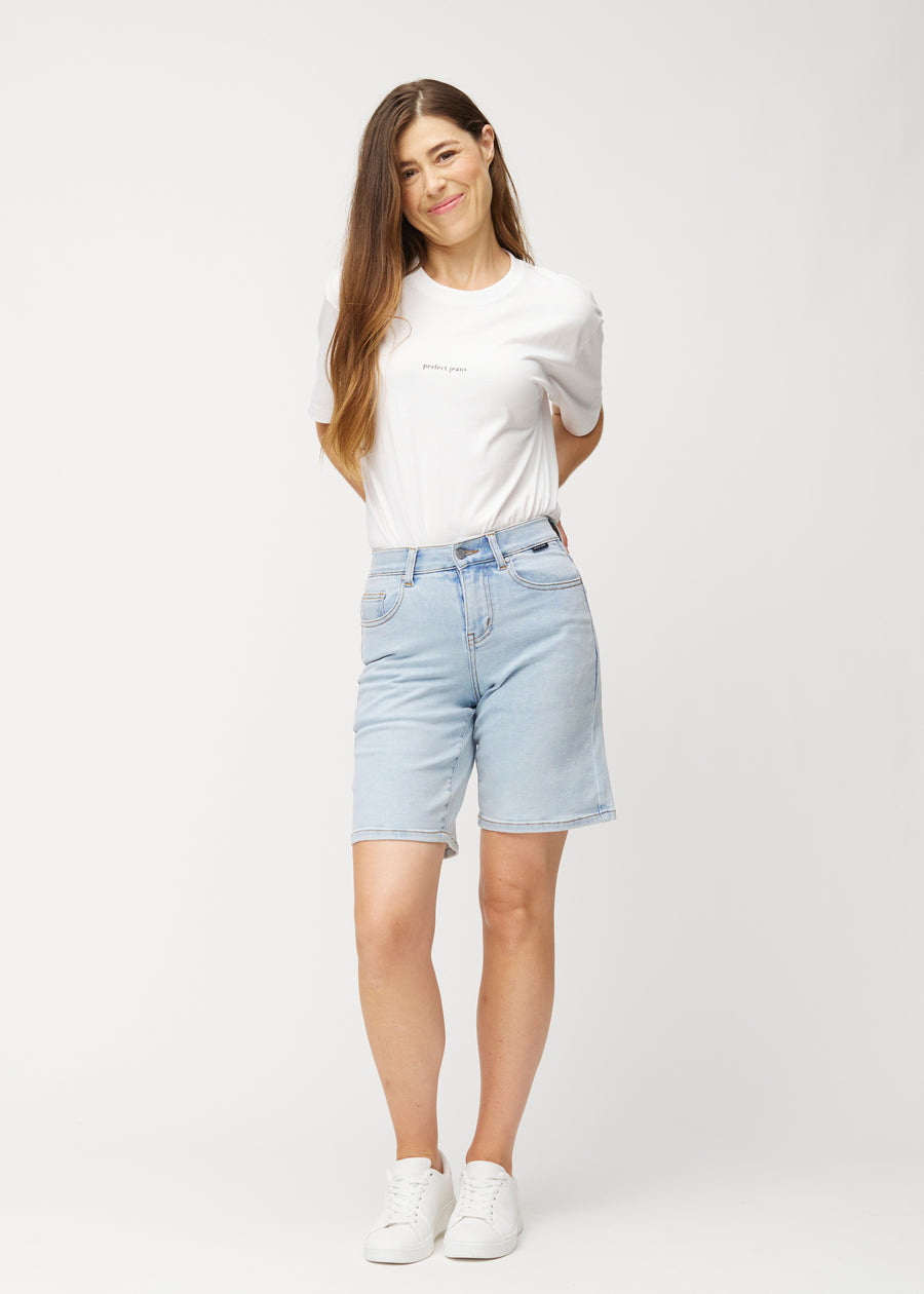Helbild av modell i ljusblå Waves denimshorts för kvinnor med medelhög midja (Mid Rise) och loose fit.