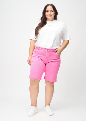 Helbild av en plus-size-modell i ljusrosa regular middle shorts.