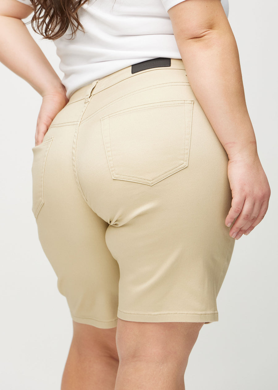 Beige regular middle shorts sedda bakifrån på nära håll på en plus-size-modell för att visa detaljer.