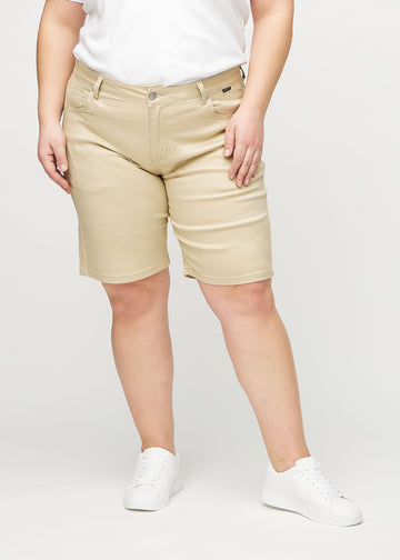 Beige regular middle shorts, modellnamn Gazelles, som går rakt ner längs benet och slutar precis ovanför knät på en plus-size-modell, sedda framifrån.