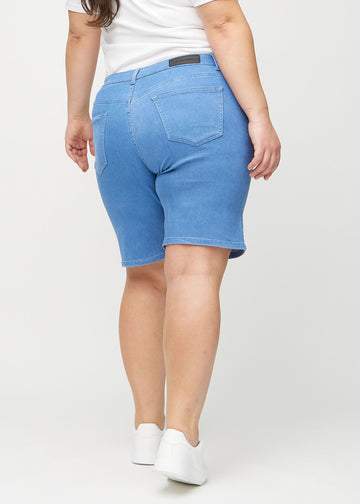 Blå regular middle shorts sedda bakifrån på en plus-size-modell, så att man kan se hela produkten.
