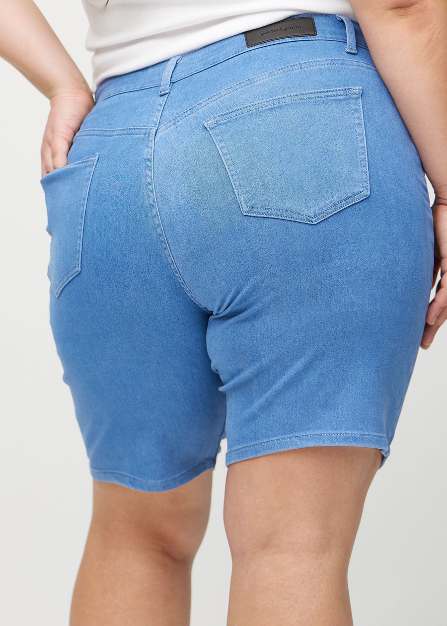 Blå regular middle shorts sedda bakifrån i närbild på en plus-size-modell för att visa detaljer.