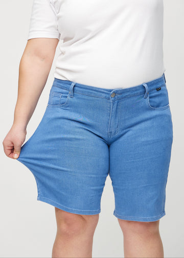 Plus-size-modellen sträcker shortsen vid låret för att visa stretch.