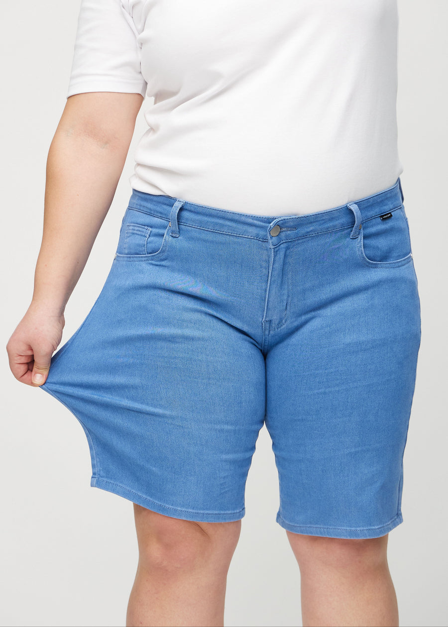 Plus-size-modellen sträcker shortsen vid låret för att visa stretch.