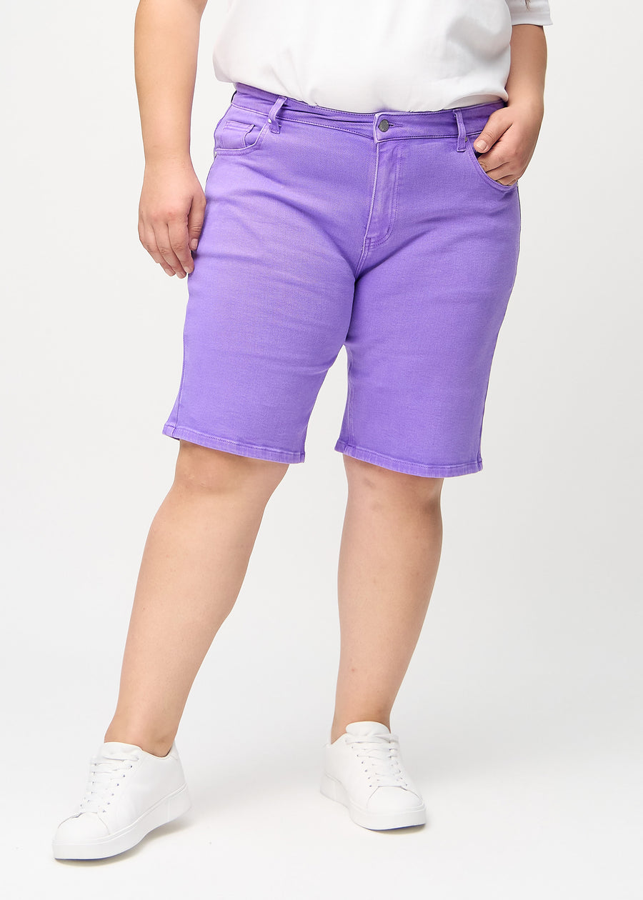 Lila regular middle shorts, modellnamn Lavenders, som går rakt ner längs benet och slutar precis ovanför knät på en plus-size-modell, sedd framifrån.