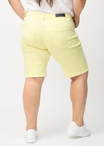 Ljusgula regular middle shorts sedda bakifrån på en plus-size-modell, så att man kan se hela produkten.