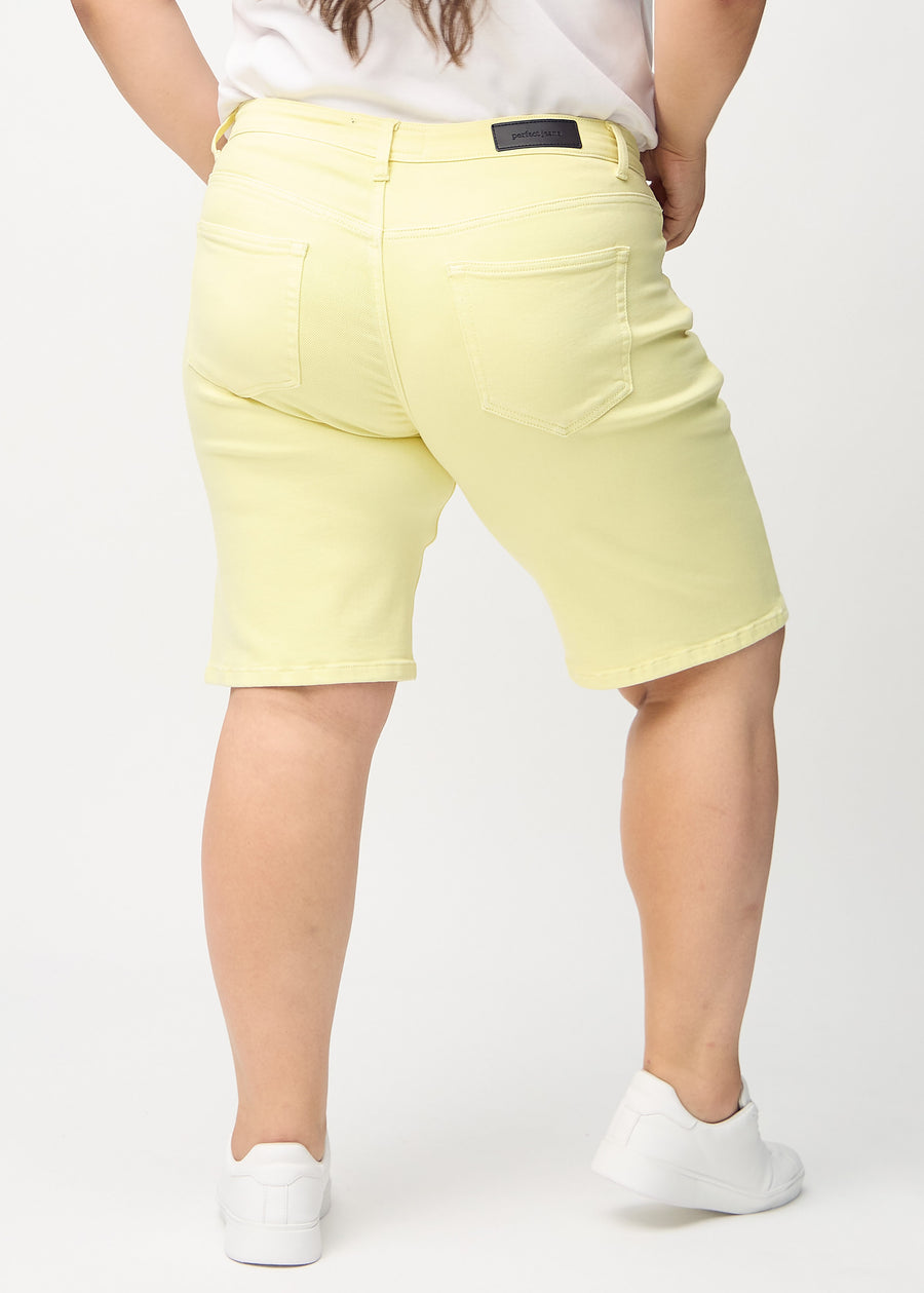 Ljusgula regular middle shorts sedda bakifrån på en plus-size-modell, så att man kan se hela produkten.