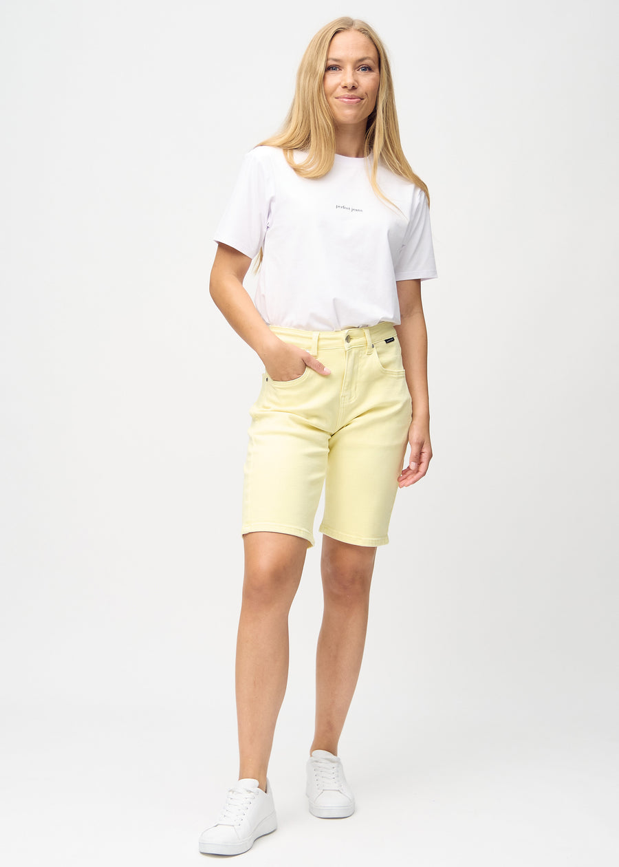 Helbild av modell i ljusgula regular middle shorts.