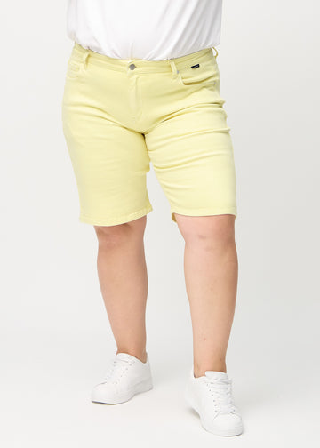 Ljusgula regular middle shorts, modellnamn Lemonades, som går rakt ner längs benet och slutar precis ovanför knäet på en plus-size-modell, sedda framifrån.
