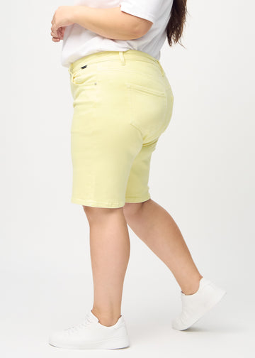 Ljusgula regular middle shorts sedda från sidan på en plus-size-modell.