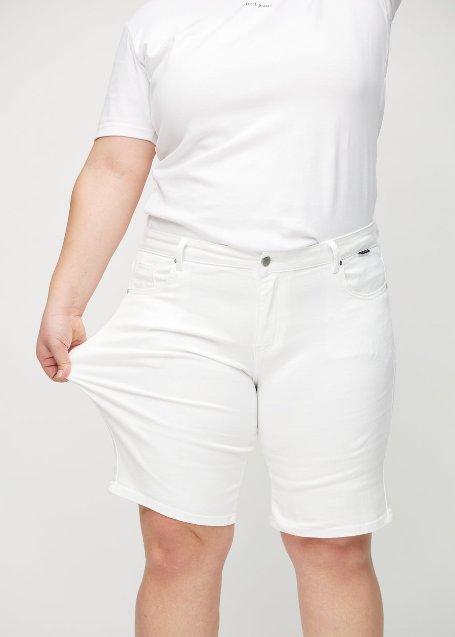 Plus size-modellen sträcker ut shortsen vid låret för att visa stretch.