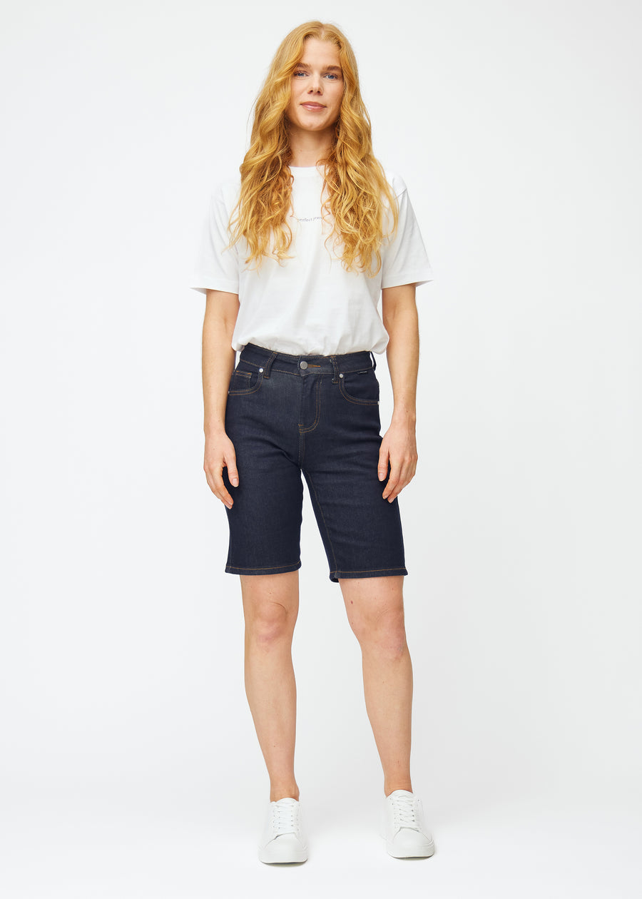 Helbild av modell i mörkblå denimshorts för dam i färgen Midnights med regular passform.