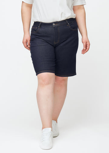Mörkblå denimshorts för dam i färgen Midnights med regular passform sett framifrån på plus-size modell.