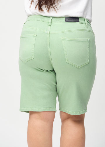 Ljusgröna regular middle shorts sedda bakifrån i närbild på en plus-size-modell för att visa detaljer.