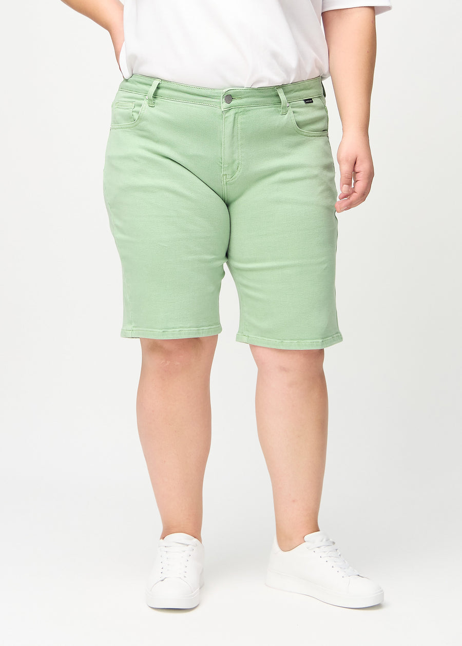 Ljusgröna regular middle shorts, modellnamn Mints, som går rakt ner längs benet och slutar precis ovanför knät på en plus-size-modell, sedda framifrån.