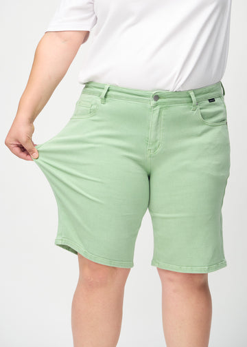 Plus-size-modellen sträcker ut shortsen vid låret för att visa stretch.