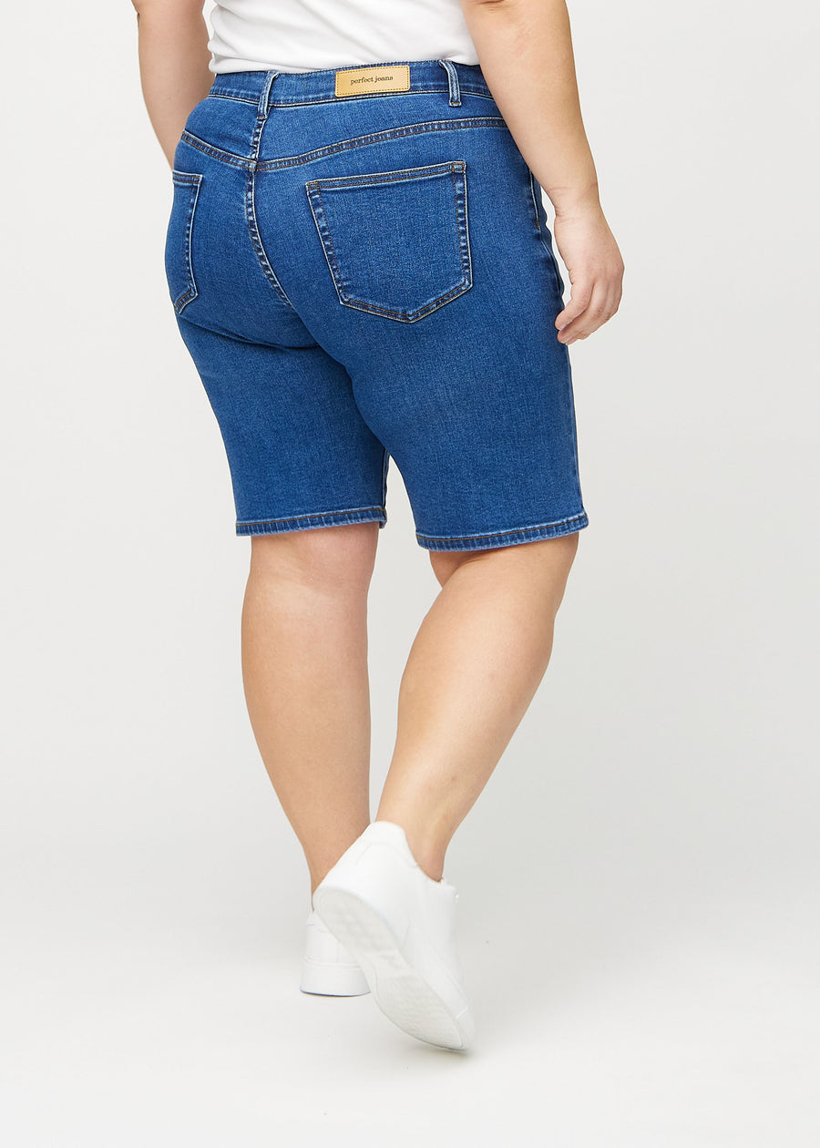 Mörk denim regular middle shorts sedd bakifrån på en plus-size-modell, så att man kan se hela produkten.