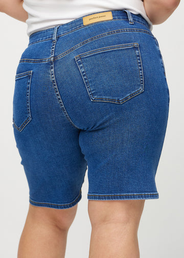 Mörk denim regular middle shorts sedd bakifrån i närbild på en plus-size-modell för att visa detaljer.