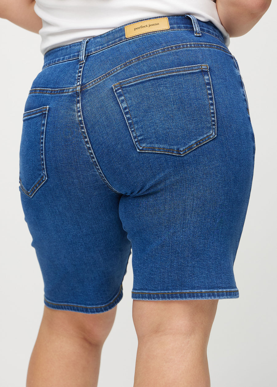 Mörk denim regular middle shorts sedd bakifrån i närbild på en plus-size-modell för att visa detaljer.