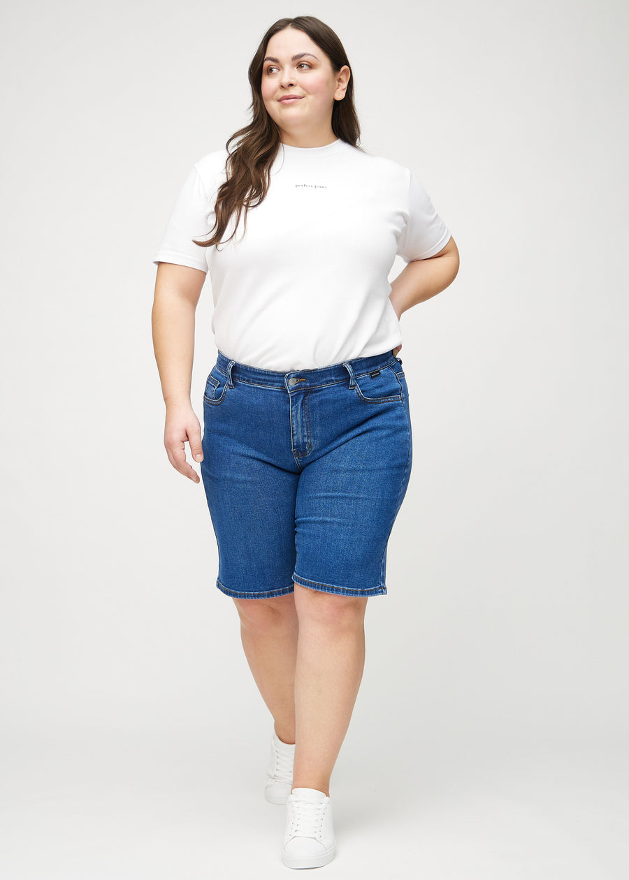 Helbild av en plus-size-modell i mörk denim regular middle shorts.