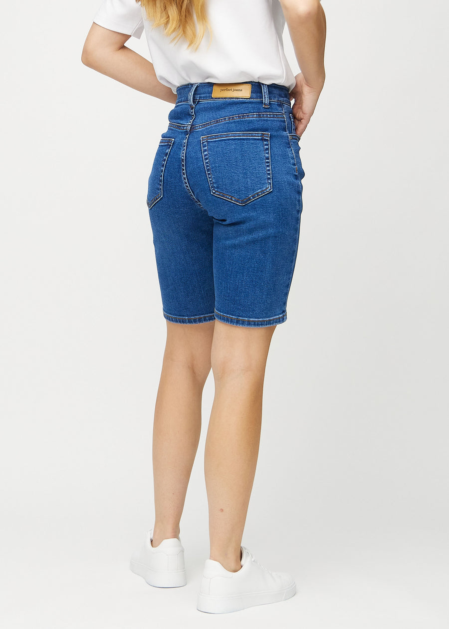 Mörk denim regular middle shorts sedd från sidan på modell.