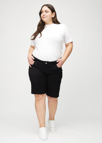Helbild av en plus-size-modell i svarta regular middle shorts.