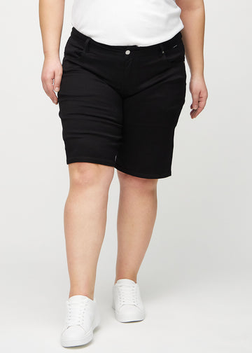 Svarta regular middle shorts, modellnamn Ravens, som går rakt ner längs benet och slutar precis ovanför knät på en plus-size-modell, framifrån.