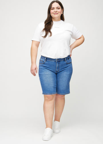 Helbild av en plus-size-modell i denim regular middle shorts.