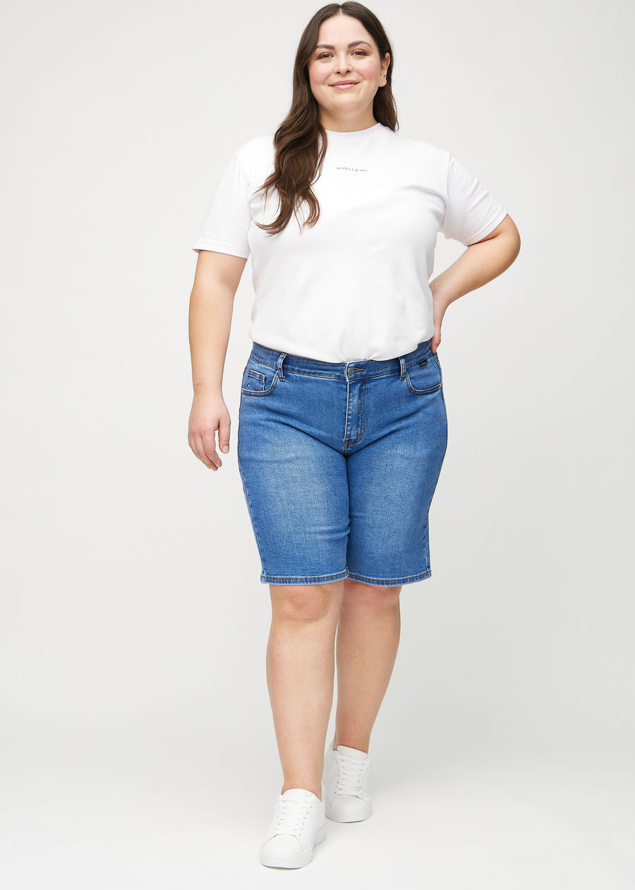 Helbild av en plus-size-modell i denim regular middle shorts.