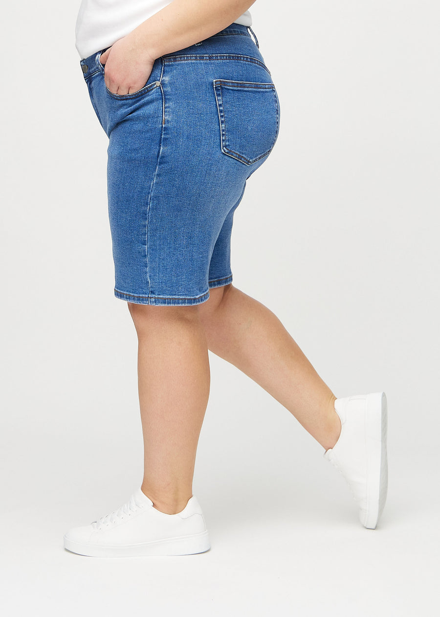 Denim regular middle shorts sedda från sidan på en plus-size-modell.