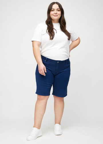 Helbild av en plus size-modell i mörkblå regular middle shorts.