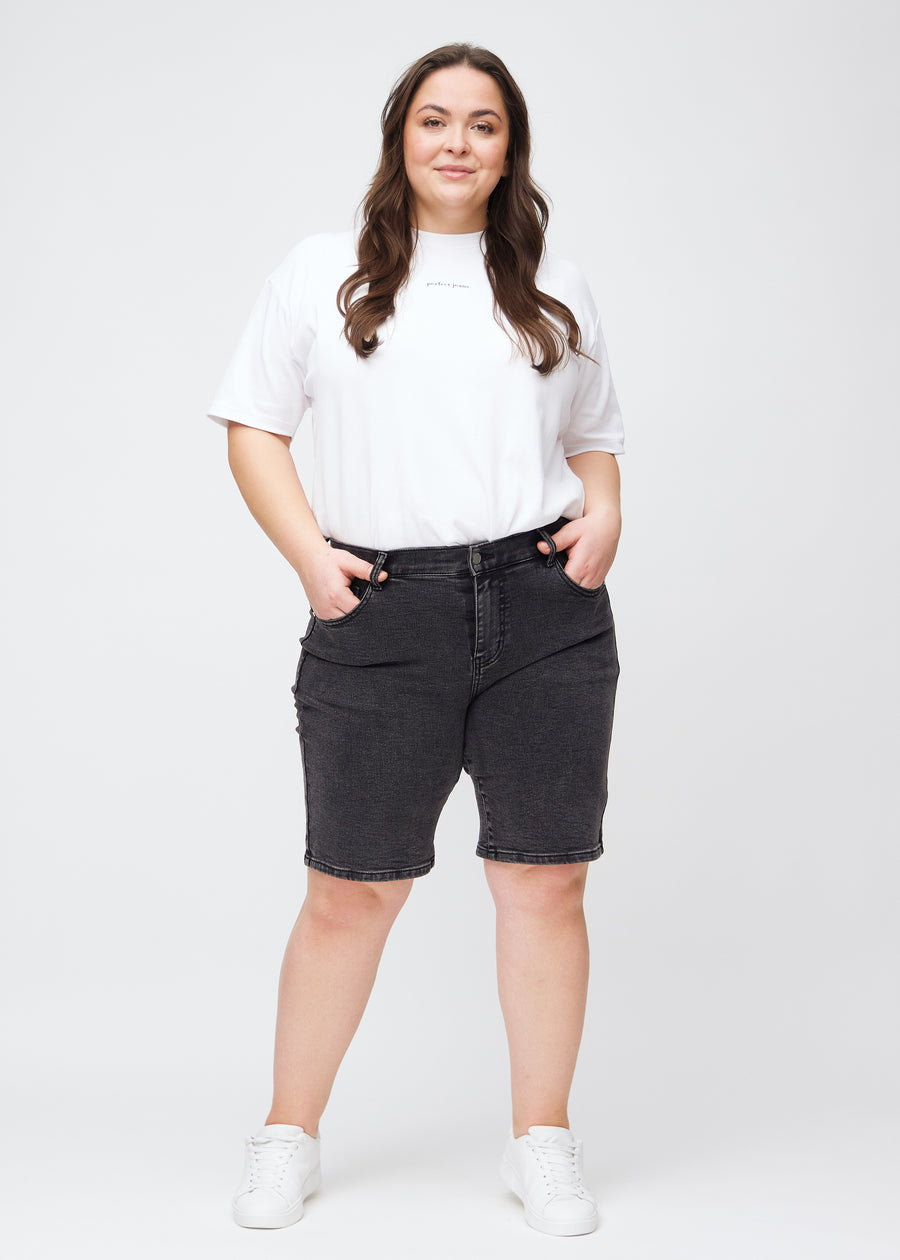 Helbild av en plus-size-modell i mörkgrå denim regular middle shorts.