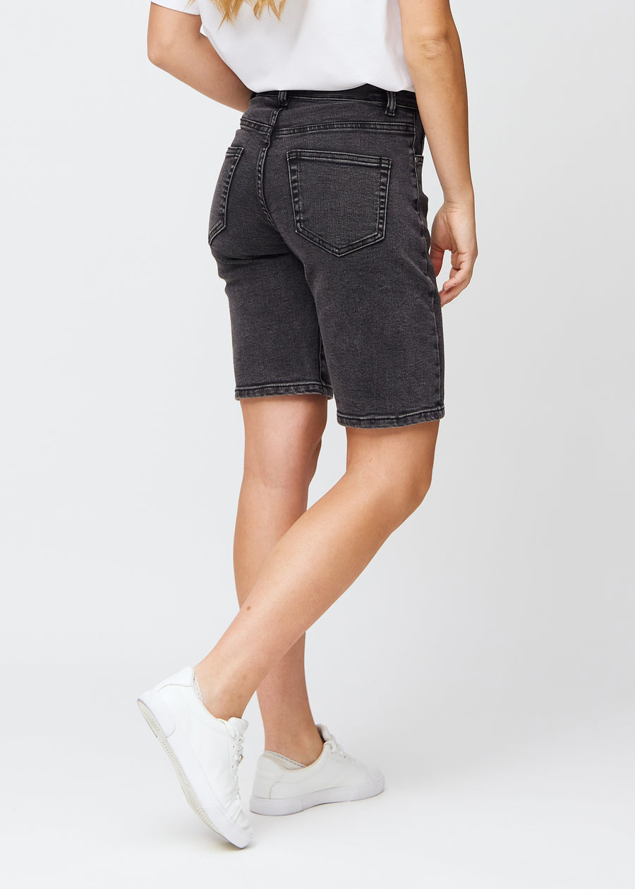 Kvinna i knälånga mörkgrå denimshorts, sedd bakifrån