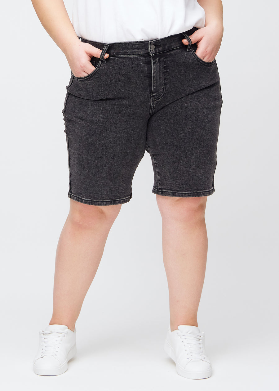Mörkgrå denim regular middle shorts, modellnamn Shadows, som går rakt ner längs benet och slutar precis ovanför knät på en plus-size-modell, sedd framifrån.