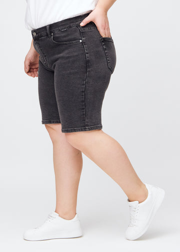 Mörkgrå denim regular middle shorts sedda från sidan på en plus-size-modell.