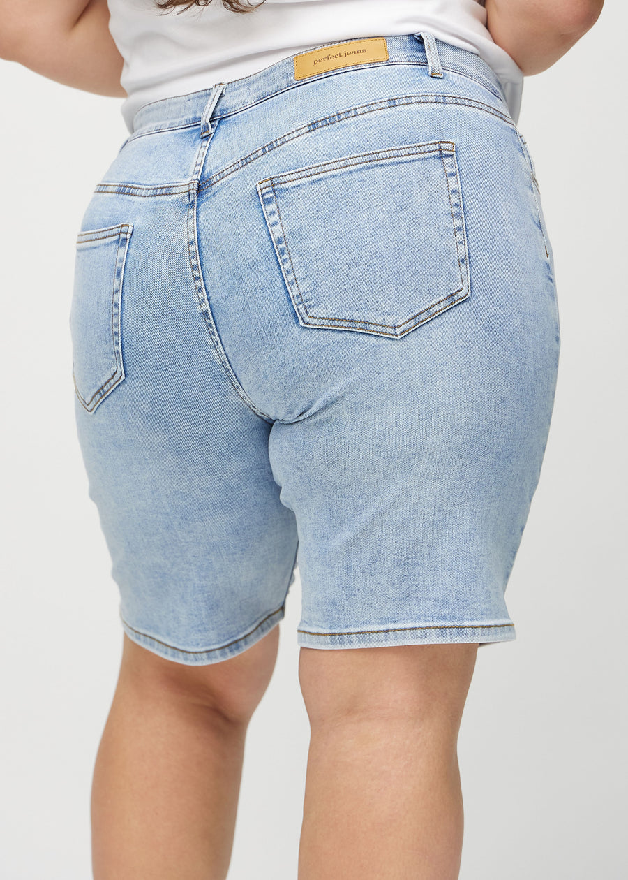 Ljus denim regular middle shorts sedd bakifrån på nära håll på en plus-size-modell för att visa detaljer.