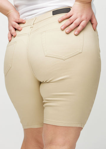 Beige skinny middle shorts sedda bakifrån i närbild på en plus-size-modell för att visa detaljer.
