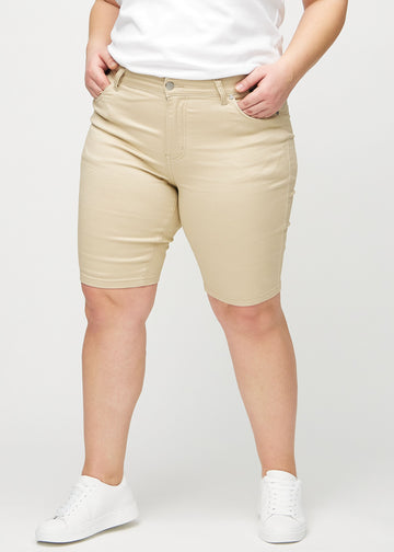 Beige skinny middle shorts, modellnamn Gazelles, som sitter tätt över låret och slutar precis ovanför knät på en plus-size-modell, framifrån.