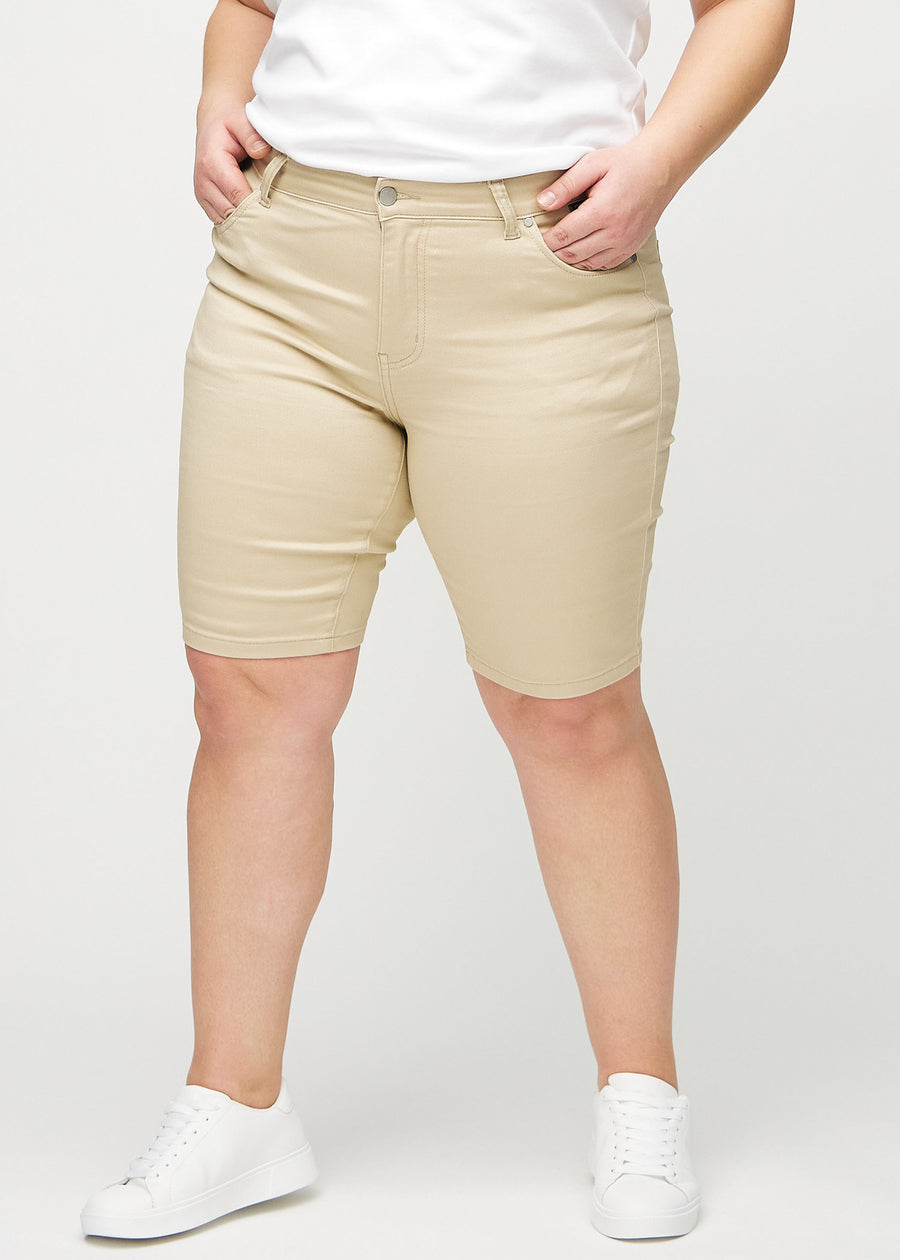 Beige skinny middle shorts, modellnamn Gazelles, som sitter tätt över låret och slutar precis ovanför knät på en plus-size-modell, framifrån.