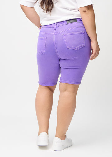 Lila skinny middle shorts sedda bakifrån på en plus size-modell, så att man kan se hela produkten.