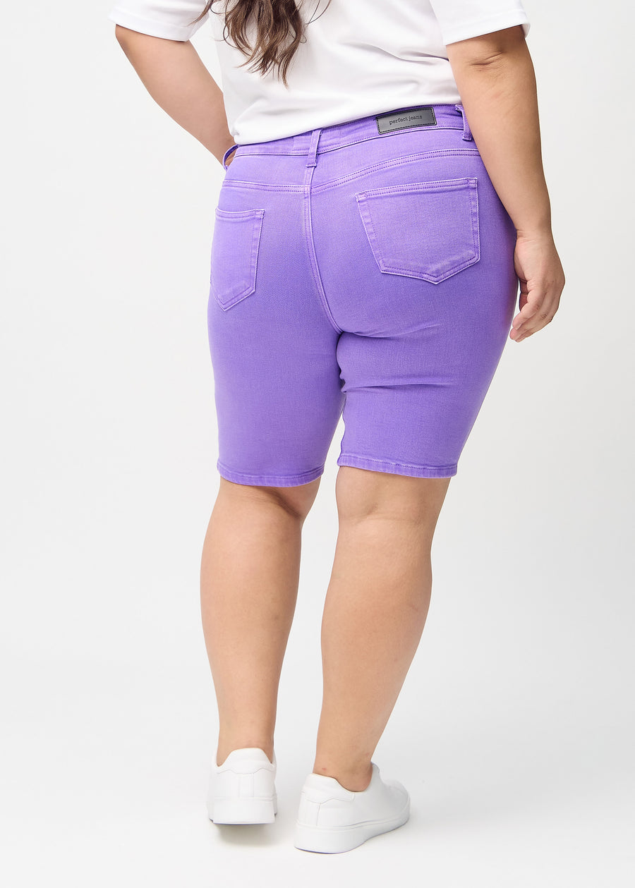 Lila skinny middle shorts sedda bakifrån på en plus size-modell, så att man kan se hela produkten.