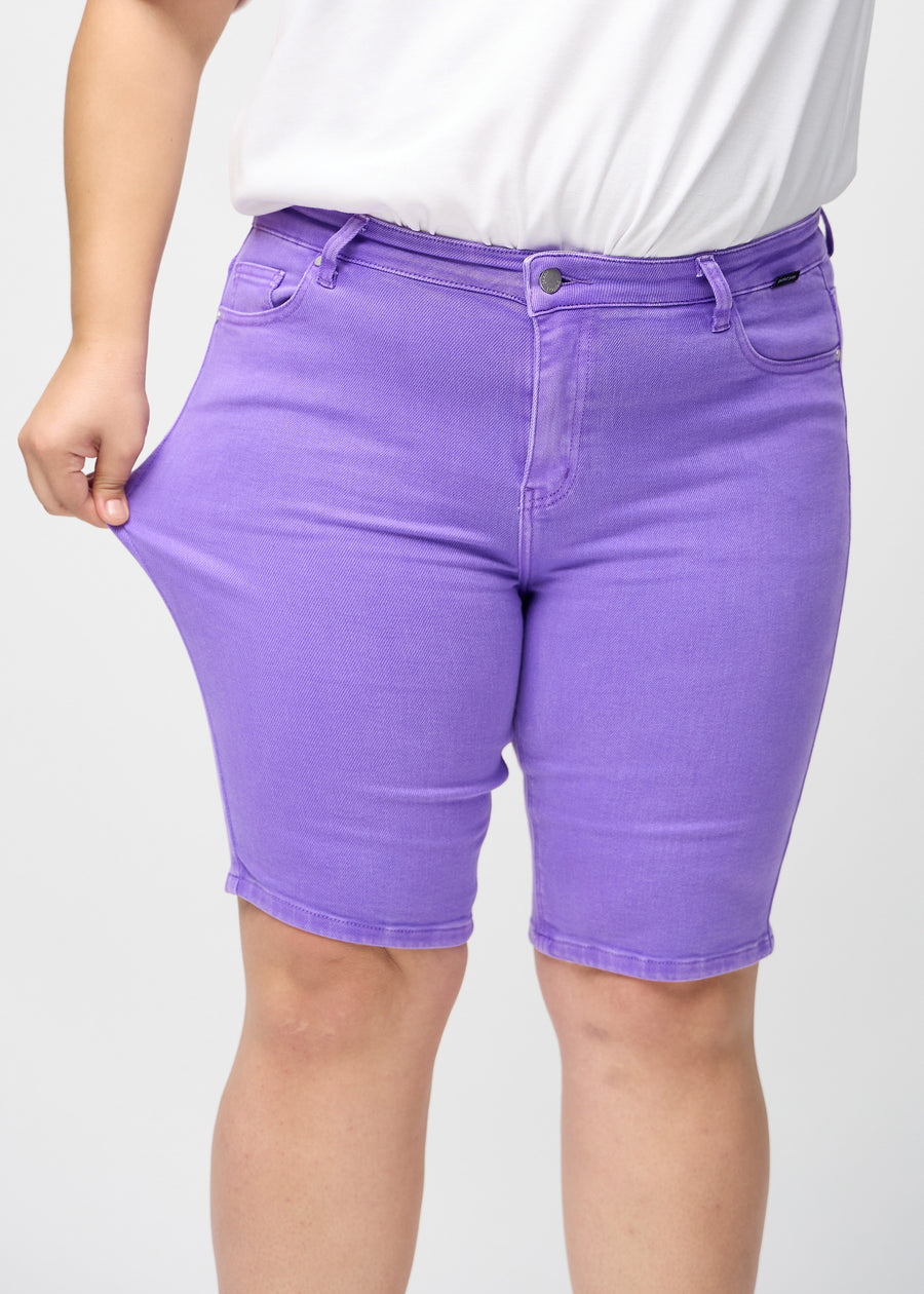 Plus size-modellen sträcker shortsen vid låret för att visa stretch.
