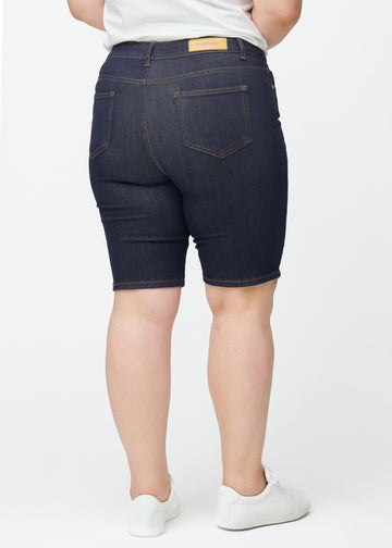 Mörkblå denimshorts för dam i färgen Midnights sett bakifrån på plus-size modell.