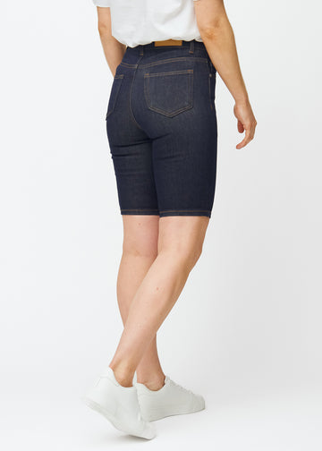 Mörkblå denimshorts för dam i färgen Midnights sett bakifrån, där längden strax över knät syns.
