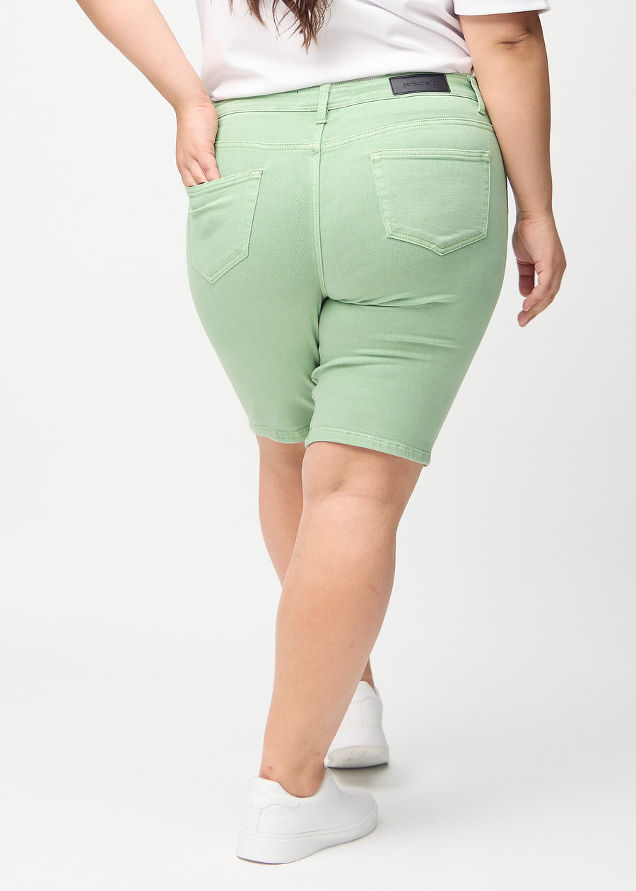 Ljusgröna skinny middle shorts sedda bakifrån på en plus-size-modell, så att man kan se hela produkten.