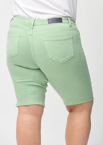 Ljusgröna skinny middle shorts sedda bakifrån i närbild på en plus-size-modell för att visa detaljer.