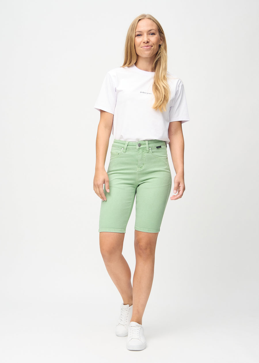 Helbild av modell i ljusgröna skinny middle shorts.